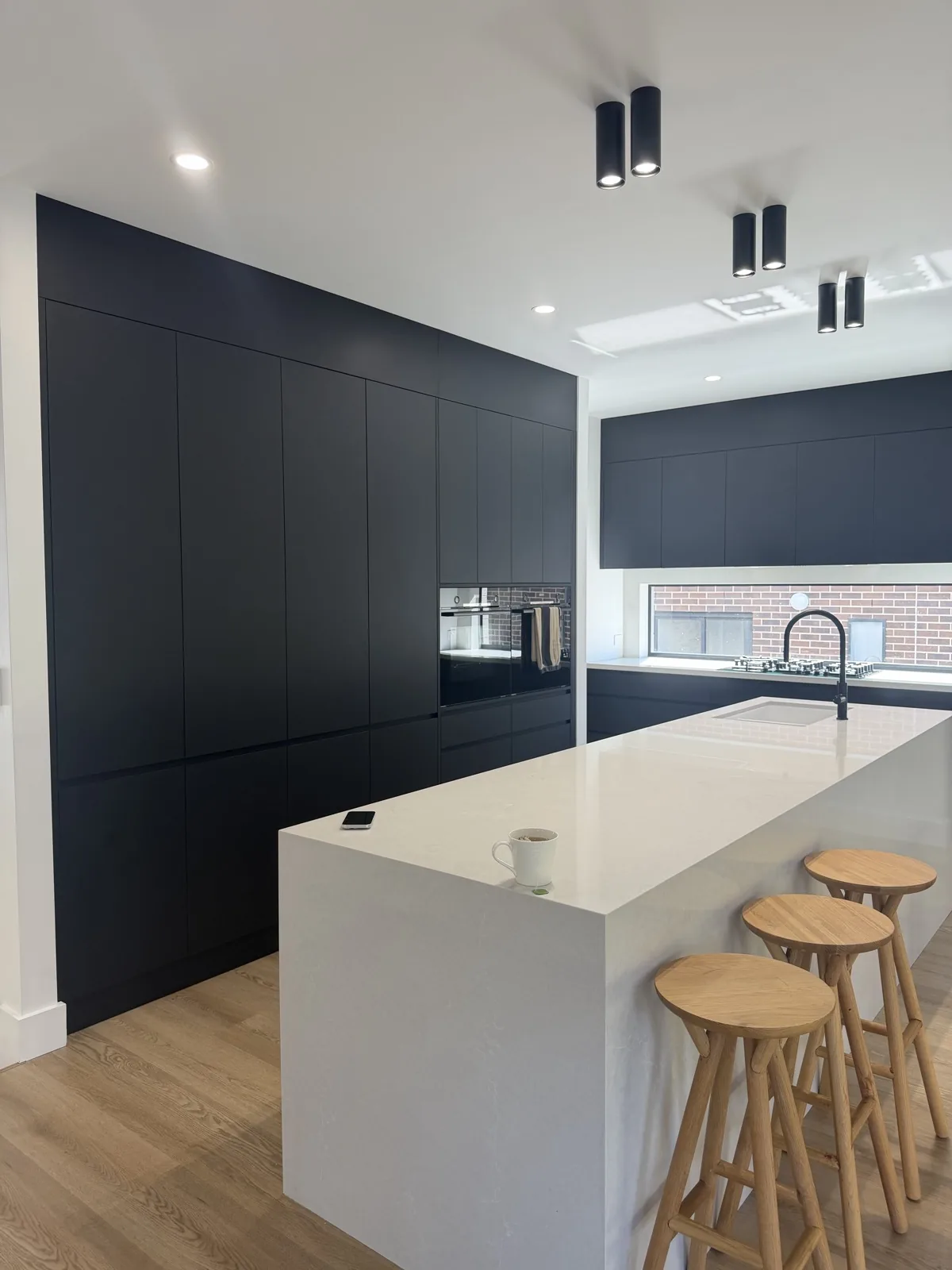 New build kitchen with navy joinery and crisp white ceilings