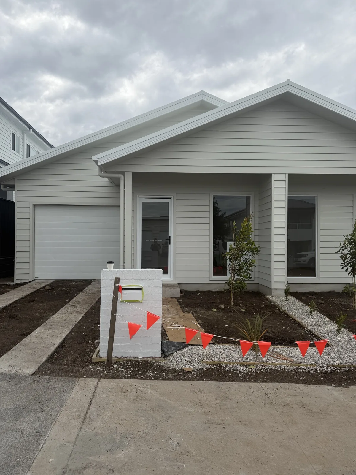 Newly painted weatherboard cottage with white cladding and garage