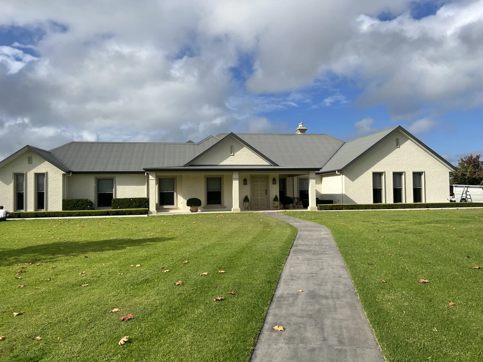 Single-storey home exterior repainted in cream with white trim
